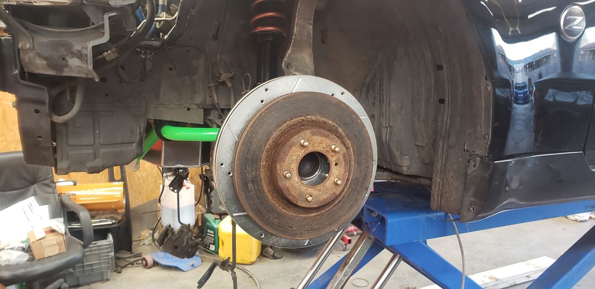 Stock base-model 350Z rotor held in front of the larger 370Z Akebono rotor