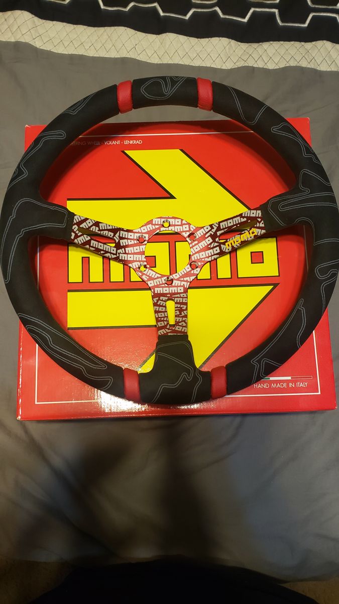 Suede MOMO steering wheel with red markers on its box