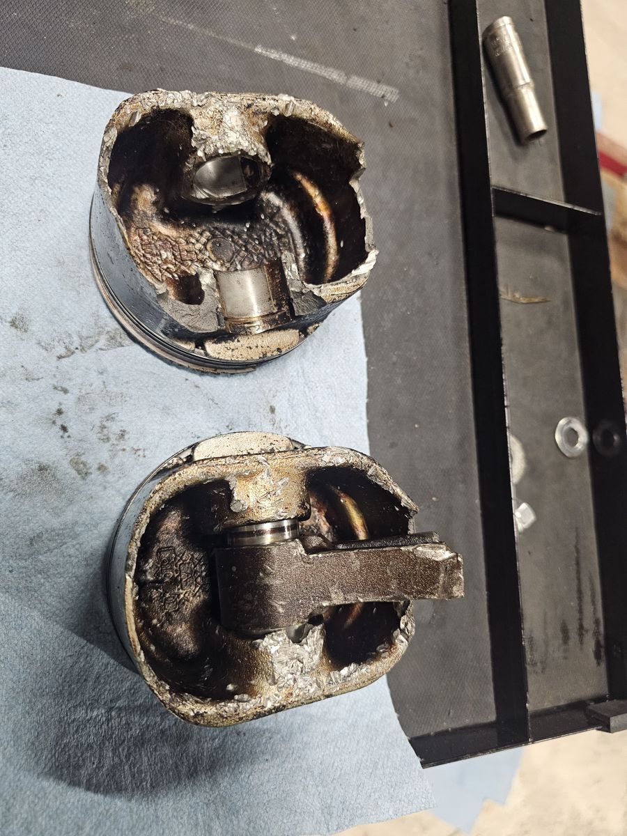 Two broken pistons, one with a snapped rod still in it