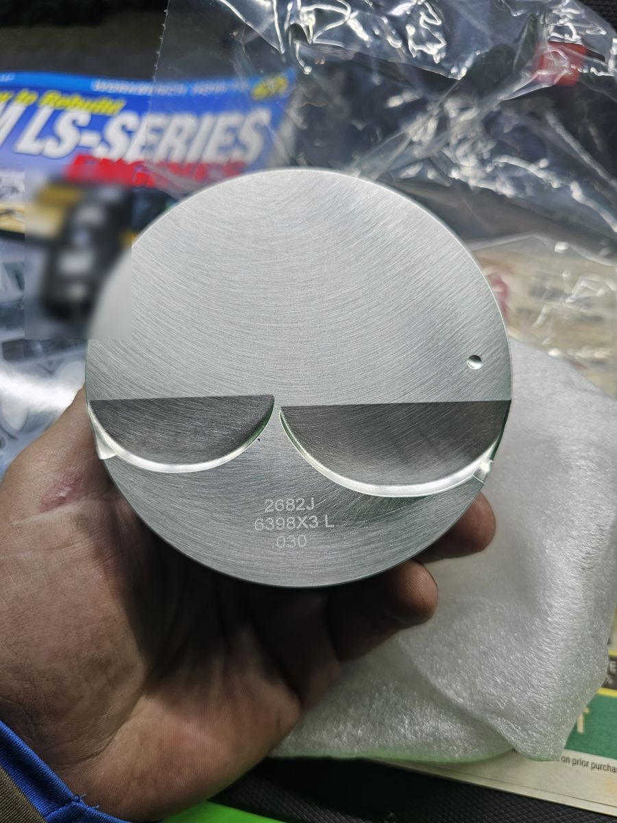 Wiseco flat-top piston held in hand, crown up